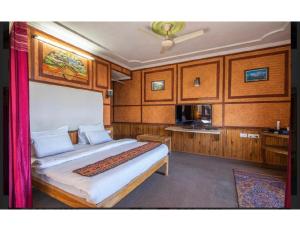 een slaapkamer met een groot bed in een boot bij Hotel Robinsson Palace, Mukteshwar in Mukteswar