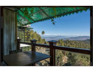 een balkon met een tafel en uitzicht op de bergen bij Hotel Robinsson Palace, Mukteshwar in Mukteswar