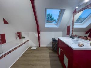 La salle de bains est pourvue d'une baignoire, d'un lavabo et d'un miroir. dans l'établissement Villa Ty Amor, à Guissény