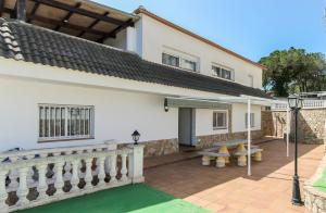een wit huis met een veranda en een patio bij Villa Atenea in Lloret de Mar