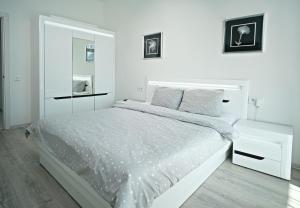敖德萨Апартаменты в Аркадии - Arcadia Sky Apartments的白色的卧室配有白色的床和镜子