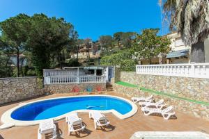 een zwembad met ligstoelen en een zwembad bij Villa Atenea in Lloret de Mar