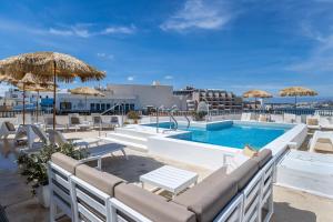 a pool with chairs and umbrellas on top of a hotel at Park Lane Boutique Aparthotel in St Paul's Bay