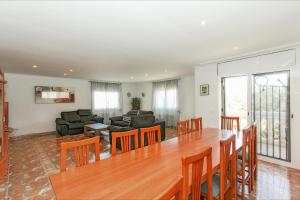 een woonkamer met een grote houten tafel en stoelen bij Villa Atenea in Lloret de Mar