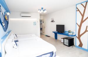 a hospital room with two beds and a tv at Welcome the sun enjoy the moon B&B in Kaohsiung