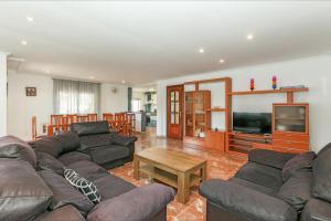 een woonkamer met een bank en een televisie bij Villa Atenea in Lloret de Mar