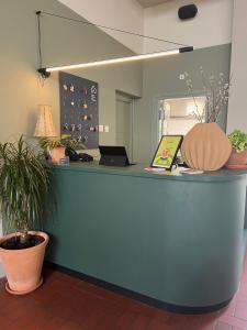 ein Büro mit einer blauen Theke mit Topfpflanzen in der Unterkunft Stadsherberg Ald Weishoès in Venlo