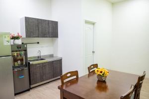 a kitchen with a wooden table and a refrigerator at Welcome the sun enjoy the moon B&B in Kaohsiung