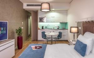 a room with a bed and a table and a kitchen at VN3 Terraces Suites by Adrez in Prague