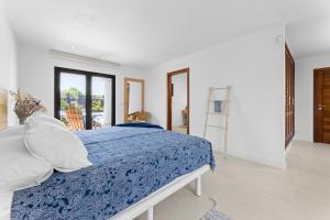 1 dormitorio con 1 cama con edredón azul y blanco en Casa Marina with pool, garden and terrace en Famara