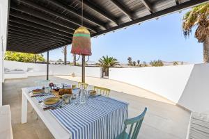 una mesa con un mantel de rayas azul y blanco en Casa Marina with pool, garden and terrace en Famara