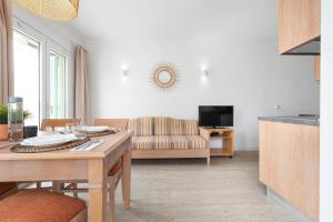 a living room with a table and a couch at Apartamentos Playa Marina in Cala Ferrera