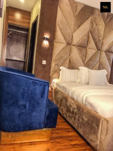 um quarto com duas camas e uma cadeira azul em KAFT2 HOTELS em Ijebu Ode