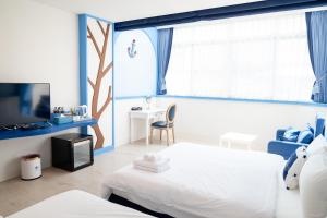 a bedroom with a bed and a tv and a desk at Welcome the sun enjoy the moon B&B in Kaohsiung