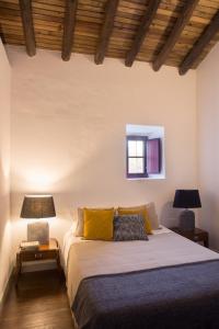 um quarto com uma cama com almofadas amarelas e uma janela em Casa de campo em Venda do Duque no Vimieiro