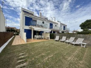 a house with white chairs and a yard at Les Dunes 3107 in Torroella de Montgrí