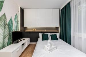 sypialnia z białym łóżkiem z zielonymi akcentami w obiekcie Prokocim Modern Studio w Krakowie