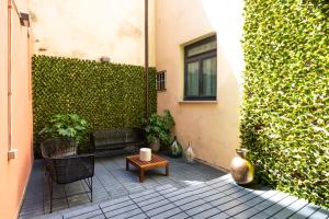 une terrasse avec un banc et un mur vert dans l'établissement Louly Spanish Steps, à Rome