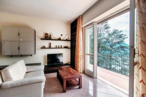 uma sala de estar com um sofá, uma televisão e uma janela em Vista Lario Apartment - Aqua Apartments em Cernobbio