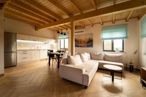 a living room with a white couch and a kitchen at Morze Tu in Stegna