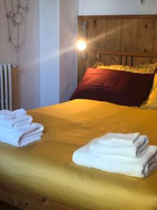 a yellow bed with towels on top of it at La casa di Nello Bini con vista su Firenze in Bagno a Ripoli