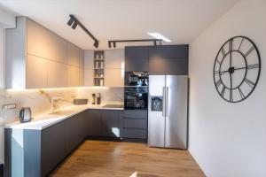 a kitchen with a refrigerator and a clock on the wall at Luxury Villa Sirius, Bast, Makarska Rivijera in Bast +34 photos