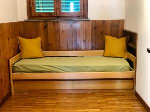 a wooden bed with two yellow pillows on it at La casa di Nello Bini con vista su Firenze in Bagno a Ripoli
