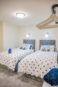a bedroom with two beds with blue pillows at Basement Bliss Hideaway in Bradford
