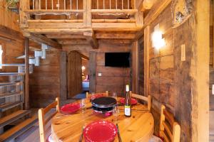 una sala da pranzo con tavolo in legno e piatti rossi di Chalet le petit bornand a Les Houches