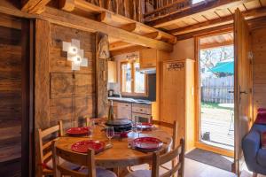 una sala da pranzo con tavolo in legno e una cucina di Chalet le petit bornand a Les Houches