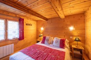 una camera con un letto in una baita di tronchi di Chalet le petit bornand a Les Houches