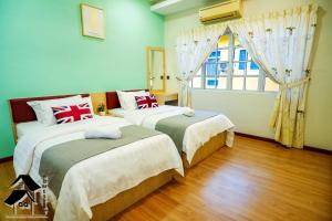 a bedroom with two beds and a window at Seremban Bungalow Cosy Homestay 舒适宽阔独立式洋房 in Seremban
