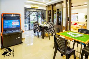 a dining room and living room with a table and a tv at Seremban Bungalow Cosy Homestay 舒适宽阔独立式洋房 in Seremban