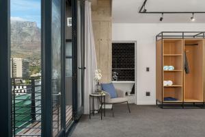 a bathroom with a tub and a chair and a balcony at Neighbourgood Loop Street in Cape Town