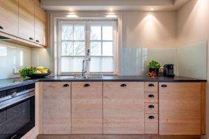 a kitchen with wooden cabinets and a sink at Traum-Landhaus-Terpstich-5000-qm-Refugium-Urlaub-in-Morsum-Sylt-vom-Feinsten in Morsum