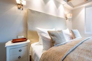 a bedroom with a bed with white sheets and pillows at Traum-Landhaus-Terpstich-5000-qm-Refugium-Urlaub-in-Morsum-Sylt-vom-Feinsten in Morsum
