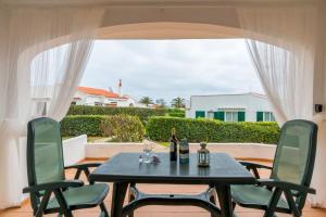 una mesa y sillas en un patio con ventana en Bonito apartamento, tranquilo y espacioso., en S'Algar