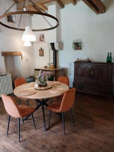 a dining room with a table and chairs at Gite Les 3 Toitures Ecogite le Luquet Saint Beauzeil 82 in Saint-Beauzeil