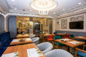 ein Restaurant mit Holztischen und -stühlen sowie einem Kronleuchter in der Unterkunft Best Nobel HotelS Old City İstanbul-Special category in Istanbul
