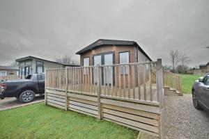 a tiny house with a wooden fence in a yard at Tranquility at Chantry Lodge in Clitheroe