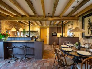 a kitchen and dining room with a table and chairs at The Coach House at Stoneythorpe in Southam
