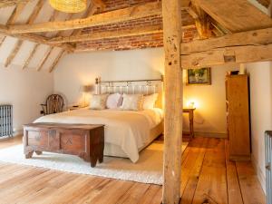 a bedroom with a bed and a wooden floor at The Coach House at Stoneythorpe in Southam