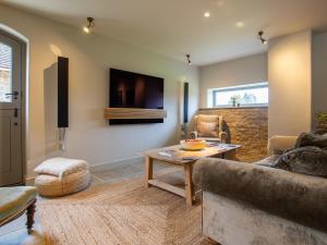 a living room with a couch and a table at The Coach House at Stoneythorpe in Southam