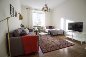 a living room with a couch and a tv at 2ndhomes Fabianinkatu Apartments in Helsinki