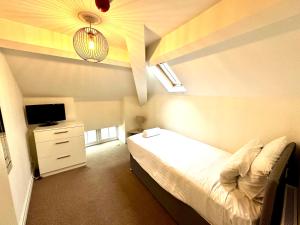 a small bedroom with a bed and a tv at West Street Mews - Serviced Accommodation in Exeter