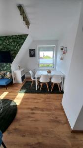 une salle à manger blanche avec une table et des chaises dans l'établissement Ferienwohnung Dschungel, à Emden