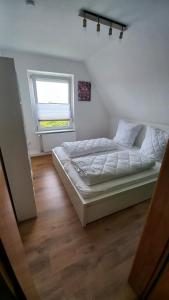 a bedroom with a bed and a window at Ferienwohnung Dschungel in Emden