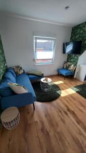 ein Wohnzimmer mit einem blauen Sofa und einem Tisch in der Unterkunft Ferienwohnung Dschungel in Emden