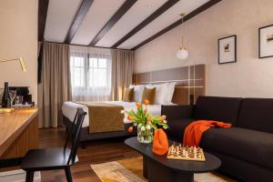 una camera d'albergo con letto e divano di Hotel Le Colombier a Obernai