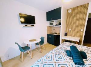 a bedroom with a bed and a table with chairs at Studio entre Disney & Paris proche lacs in Torcy